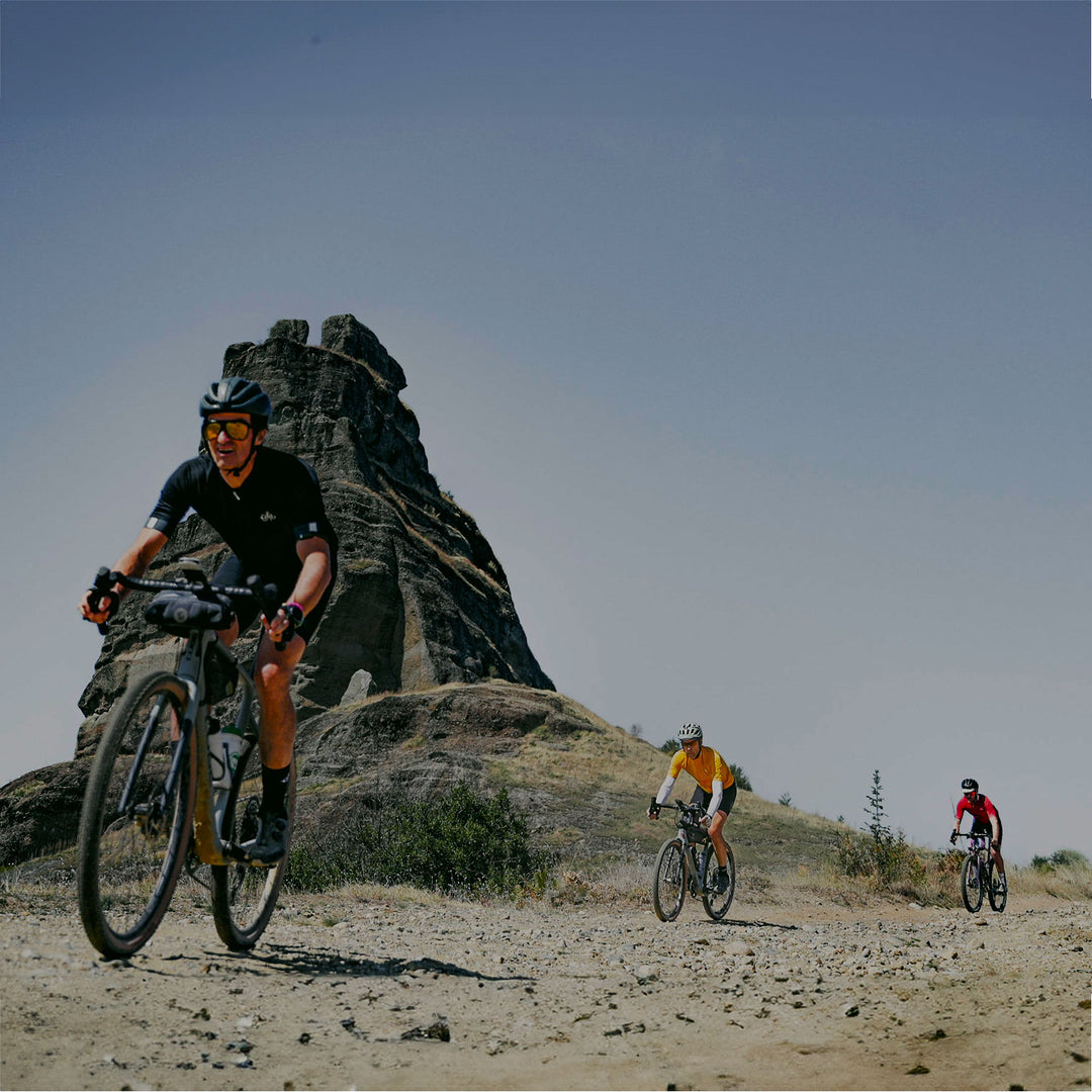 Cyclists on a gravel track wearing Sigr cycling clothing