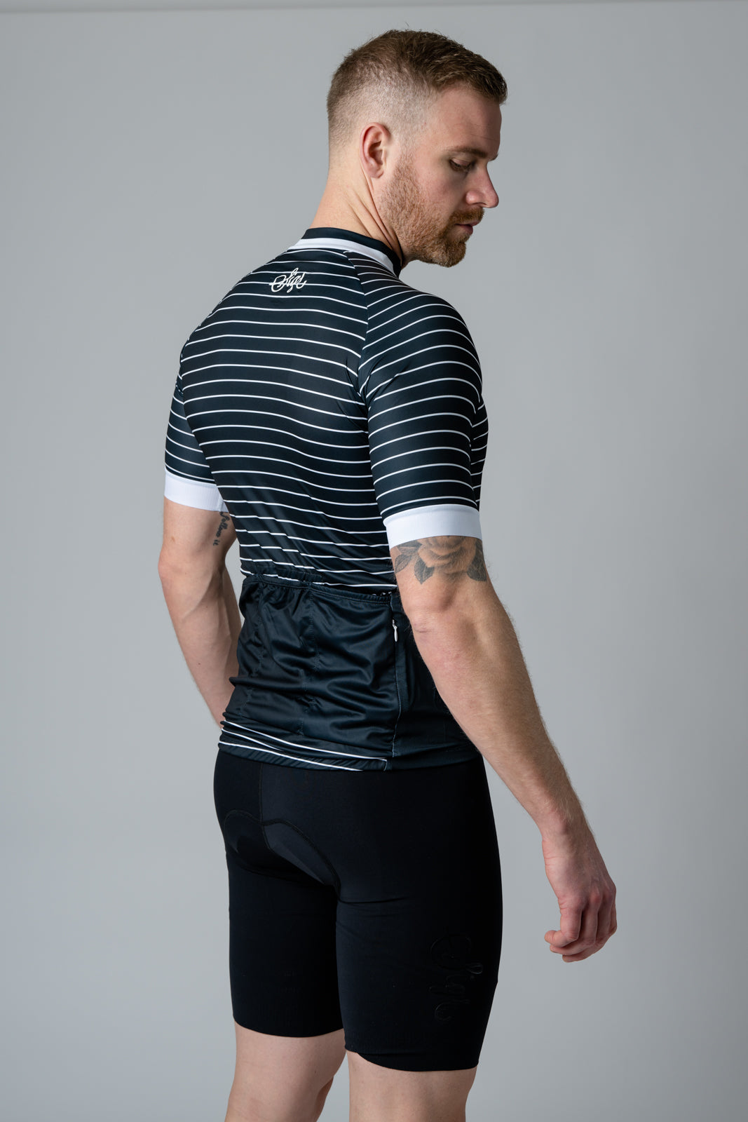 Rear view of 'Black Horizon' men's cycling jersey in black and white stripes